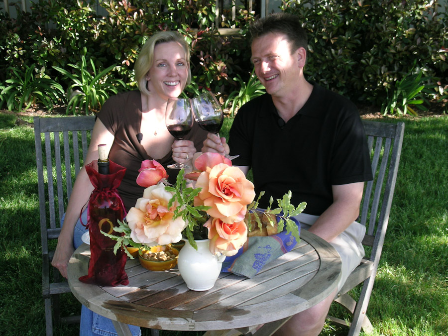 A couple at a table with glasses of wine and roses