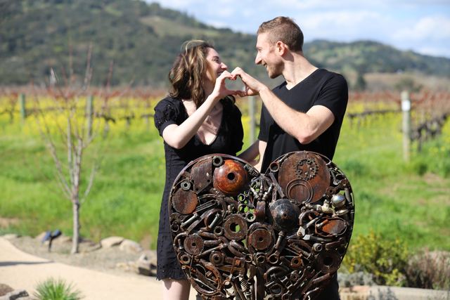 The couple making a heart shape with their hands