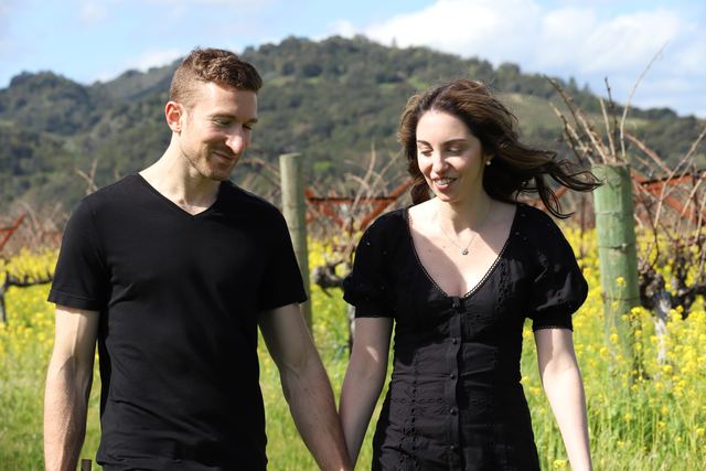 The couple hand in hand in the vineyard