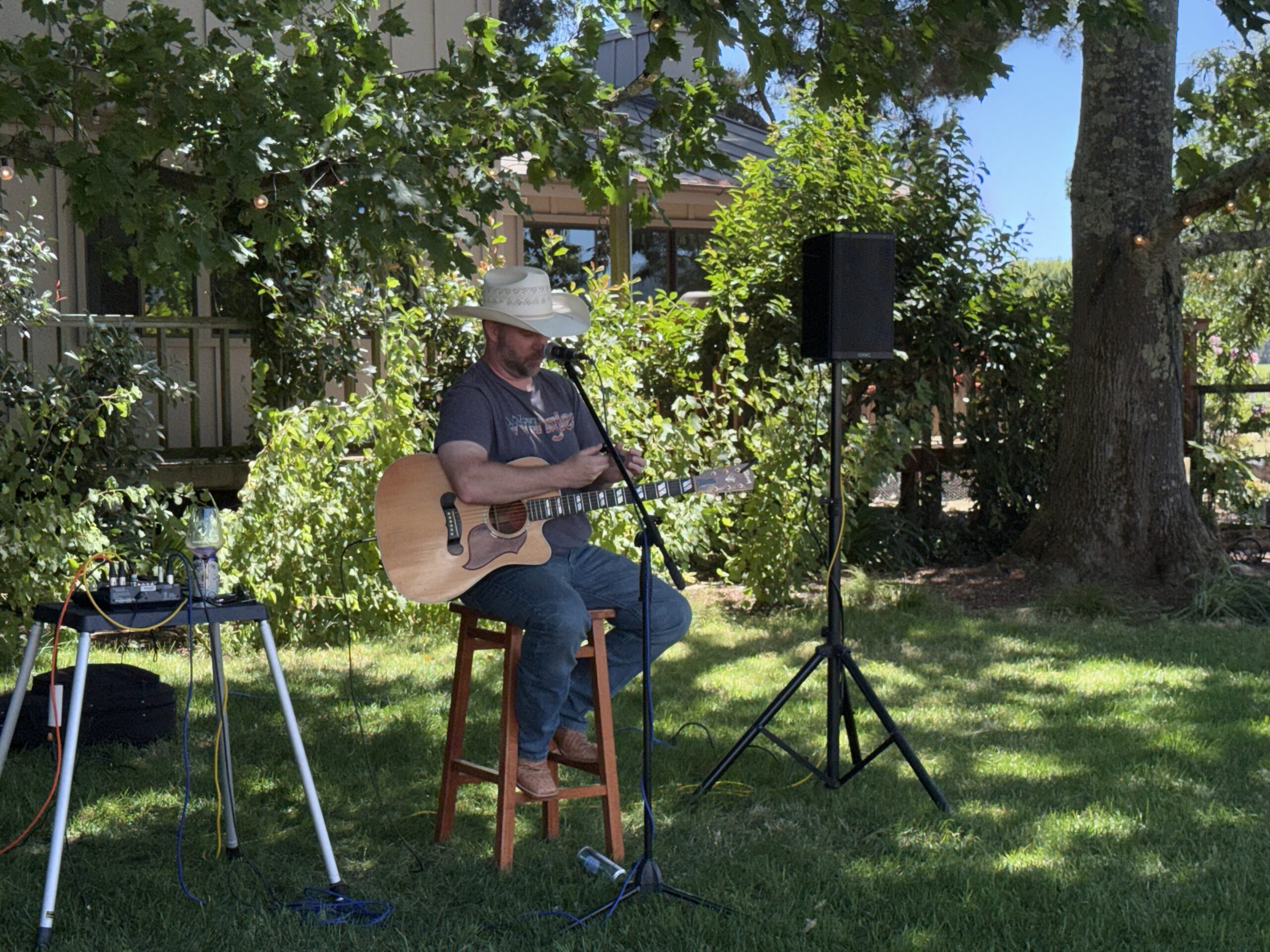 Zach Neil playing acoustic guitar on the lawn at O’Brien Estate